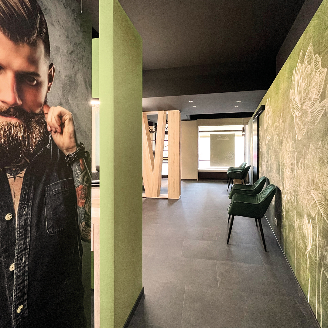 Immagine dell'area di attesa con immagine di uomo come decorazione e poltrone verdi scuro 